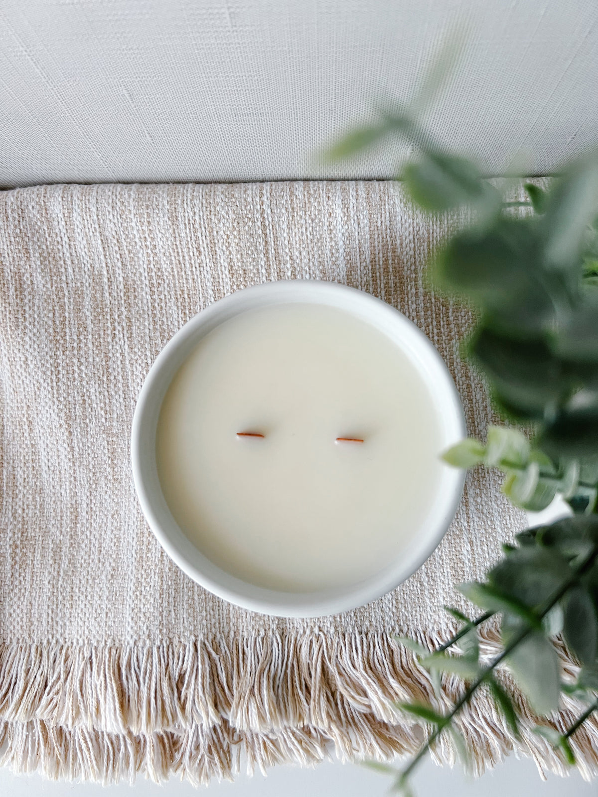 Sunday Service Collection candle styled with greenery and ceramic bowl